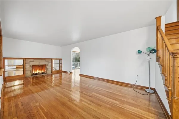 a view of empty room with wooden floor and fireplace