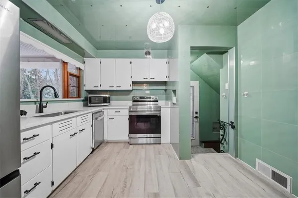 a kitchen with cabinets a oven and a clock
