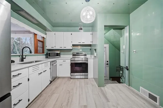 a kitchen with cabinets a oven and a clock