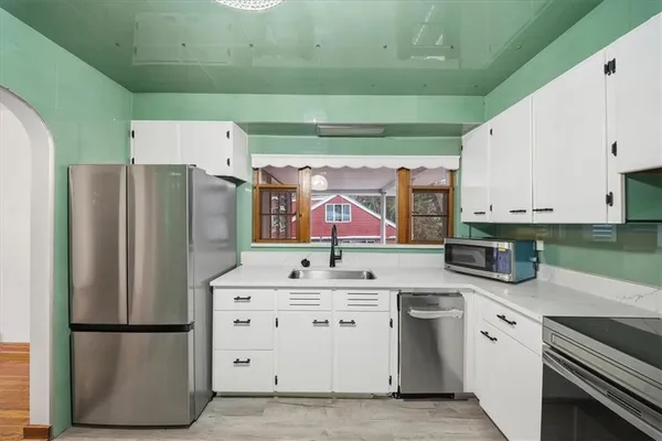 a kitchen with stainless steel appliances a refrigerator sink and cabinets