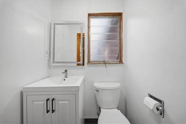 a bathroom with a toilet sink and mirror