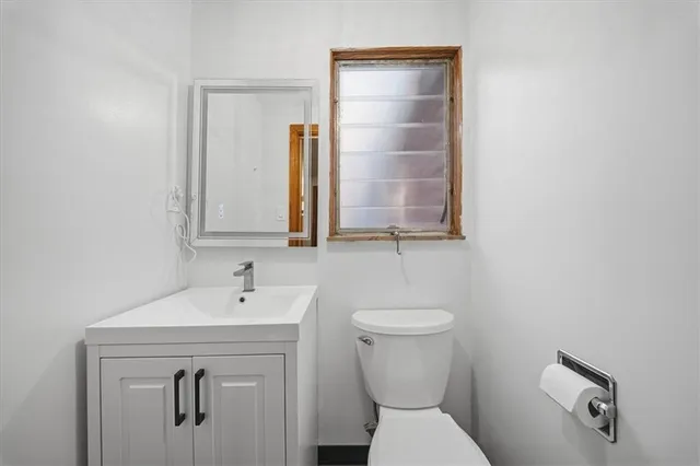 a bathroom with a toilet sink and mirror