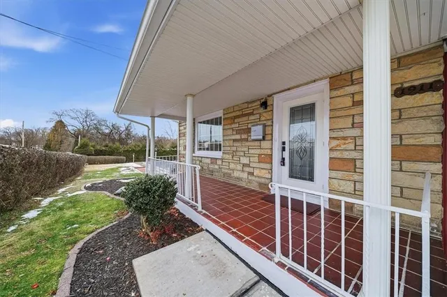a view of a porch with a floor to ceiling window next to a yard