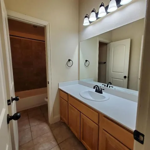 a bathroom with a sink a tub and a mirror