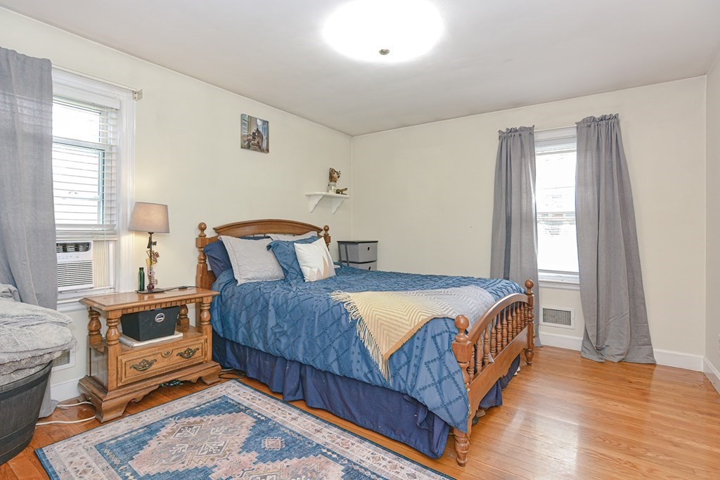 38 Spring Street Plainville, MA 02762 - Photo 11 of 23 a bedroom with a bed a stove and wooden floor