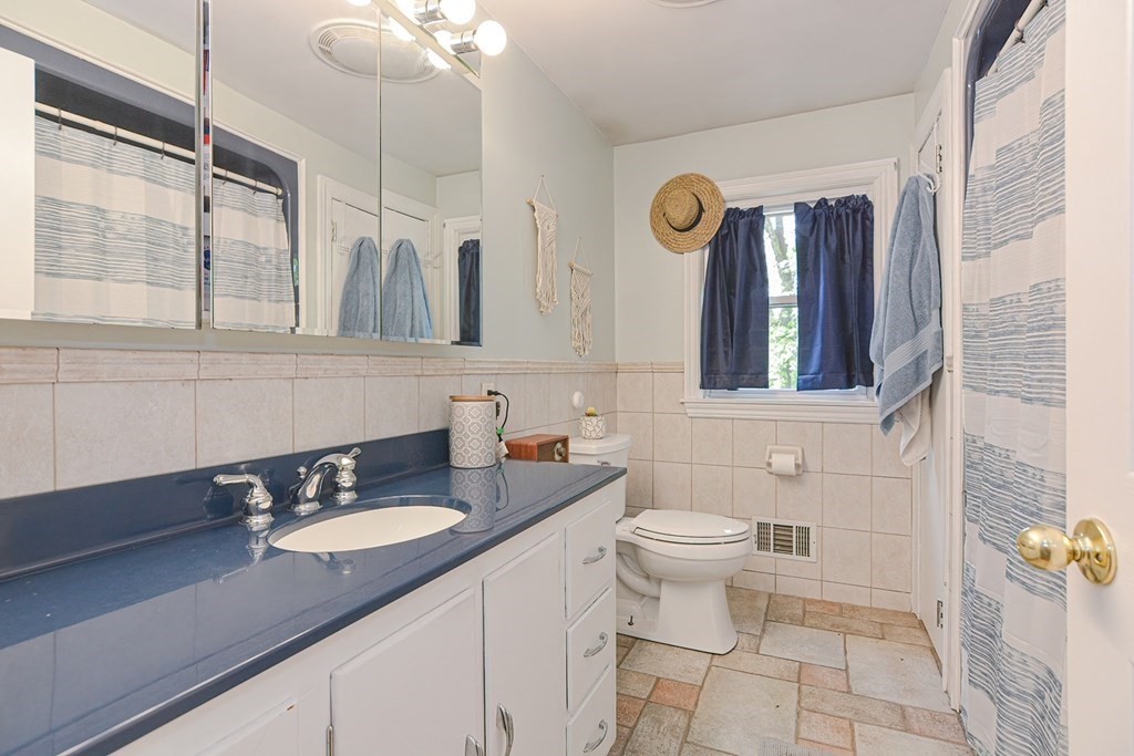 38 Spring Street Plainville, MA 02762 - Photo 16 of 23 a bathroom with a toilet a sink and mirror
