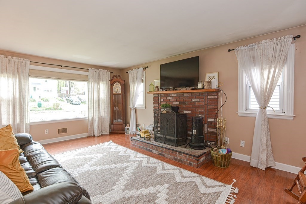 38 Spring Street Plainville, MA 02762 - Photo 5 of 23 a living room with furniture a flat screen tv and a fireplace