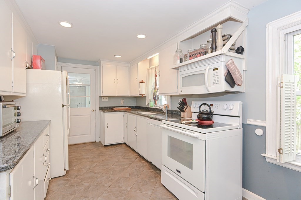 38 Spring Street Plainville, MA 02762 - Photo 9 of 23 a kitchen with a white cabinets and white appliances