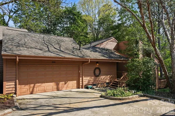 a front view of house with yard outdoor seating and covered with trees