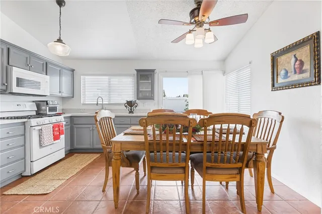 a kitchen with stainless steel appliances a table chairs and a refrigerator