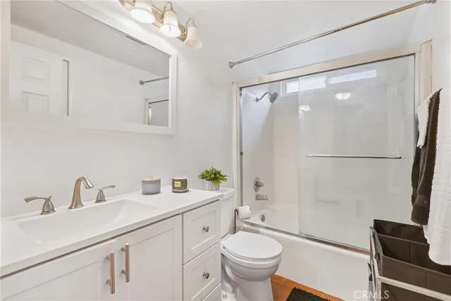 a bathroom with a sink toilet a mirror and shower