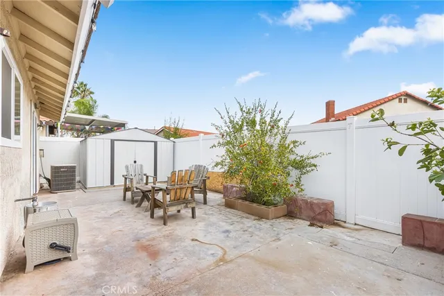 a view of a patio with a table and chairs under an umbrella