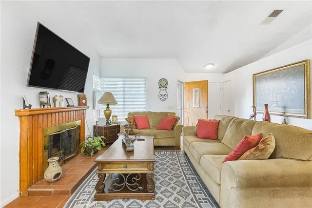 a living room with furniture a flat screen tv and a fireplace