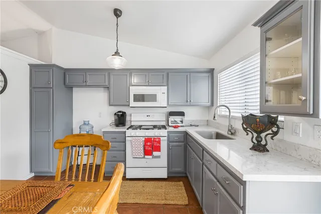 a kitchen with stainless steel appliances granite countertop a sink a stove and a wooden floors