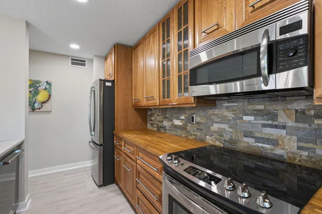 a kitchen with stainless steel appliances granite countertop a stove and a refrigerator