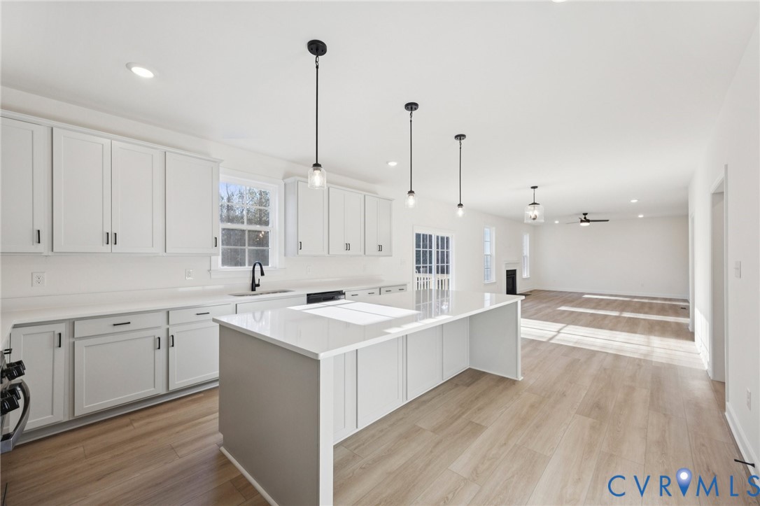 13619 Brandy Oaks Road Chesterfield, VA 23832 - Photo 8 of 28 a kitchen with a sink stove and white cabinets with wooden floor
