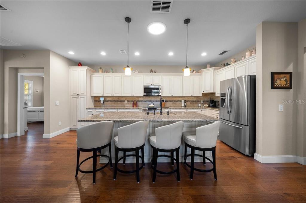 9586 Southwest 70th Loop Ocala, FL 34481 - Photo 6 of 21 a kitchen with stainless steel appliances a dining table chairs refrigerator sink and microwave