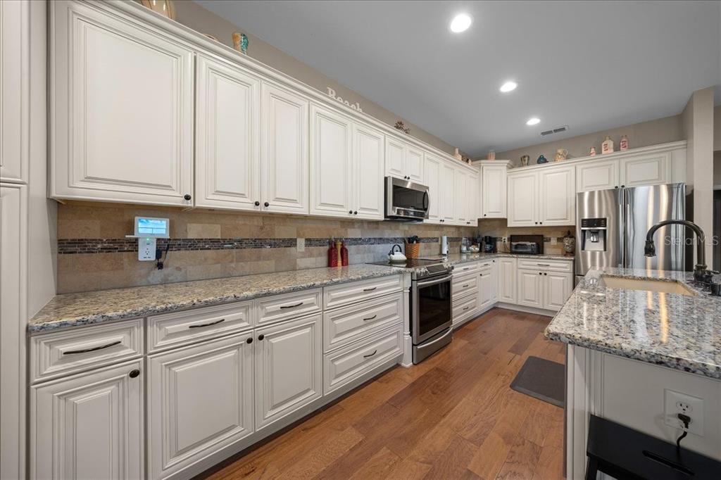 9586 Southwest 70th Loop Ocala, FL 34481 - Photo 7 of 21 a kitchen with kitchen island granite countertop white cabinets and white stainless steel appliances