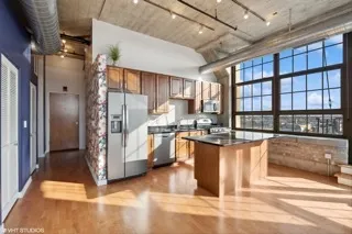 a kitchen with stainless steel appliances granite countertop a refrigerator a sink and a stove