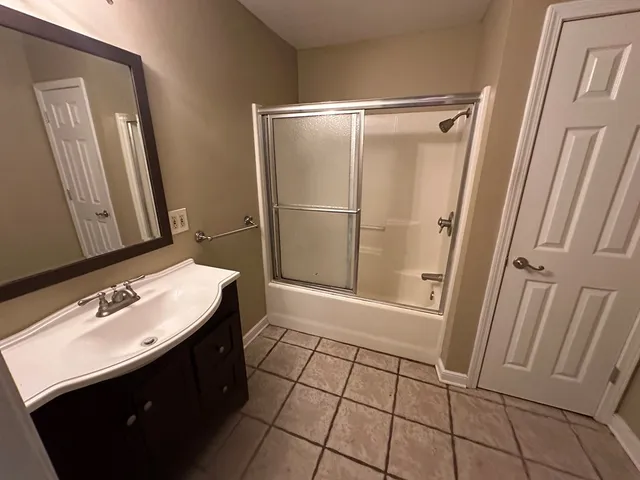 a bathroom with a sink a mirror and shower