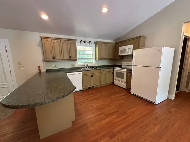 a kitchen with granite countertop a sink stove and refrigerator