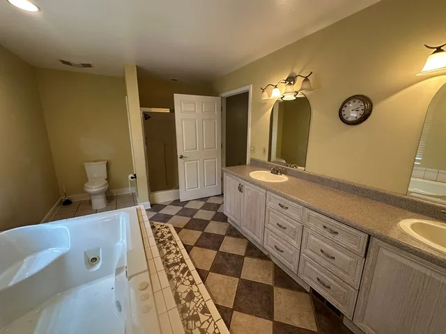 a spacious bathroom with a double vanity sink a mirror and a shower