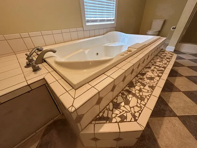 a bath tub sitting in a bathroom next to a window