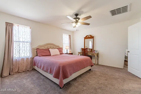 a bedroom with a bed chandelier and a window