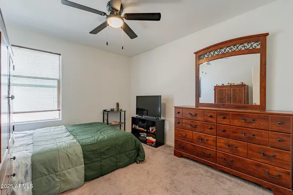 a bedroom with a bed and a flat tv screen on dresser