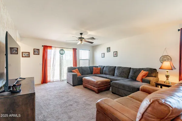 a living room with furniture a ceiling fan and a window