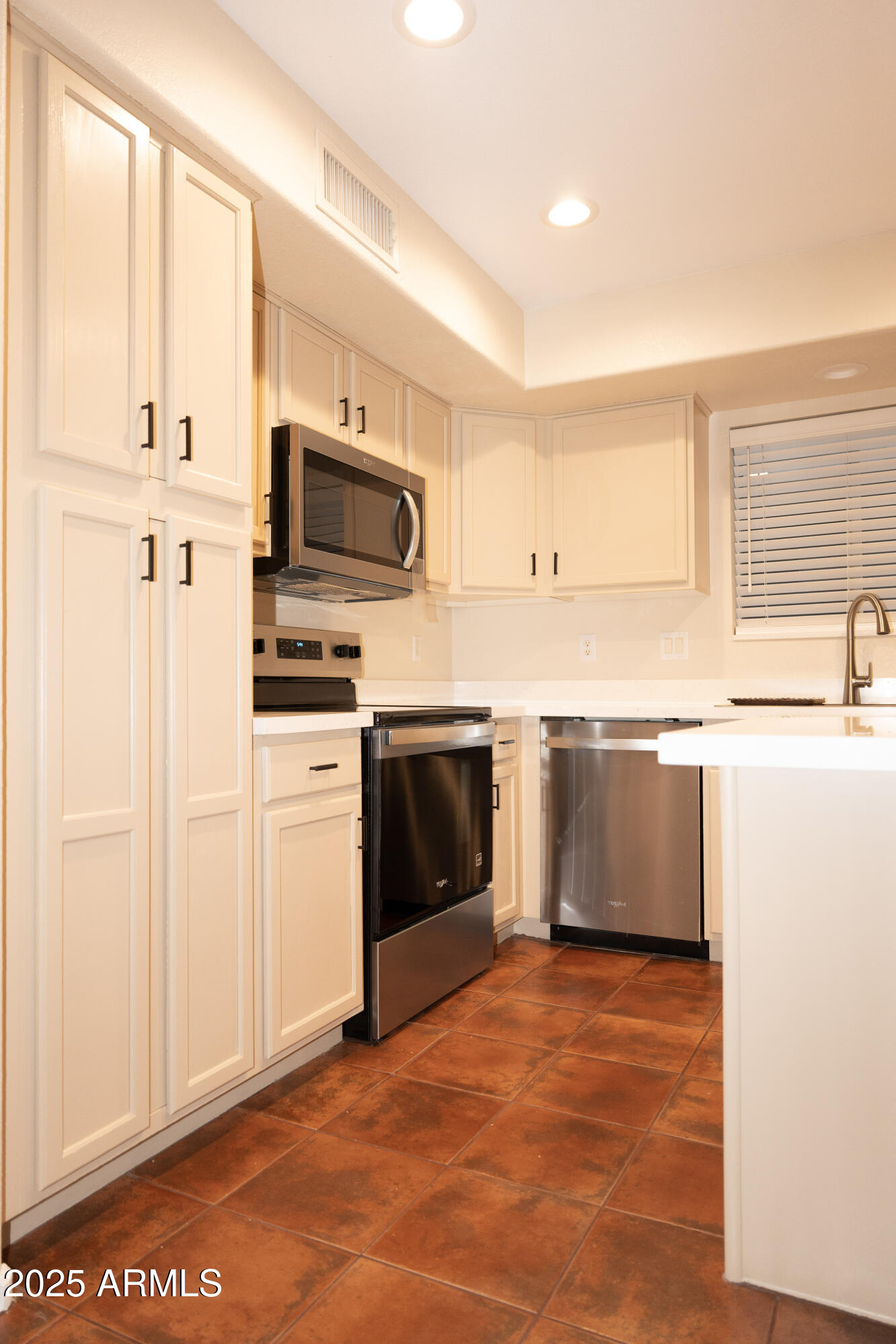 4705 East Jaeger Road Phoenix, AZ 85050 - Photo 7 of 44 a kitchen with stainless steel appliances a stove a microwave and white cabinets