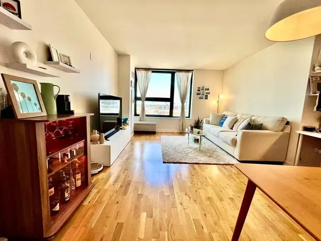 a large bedroom with wooden floor and furniture