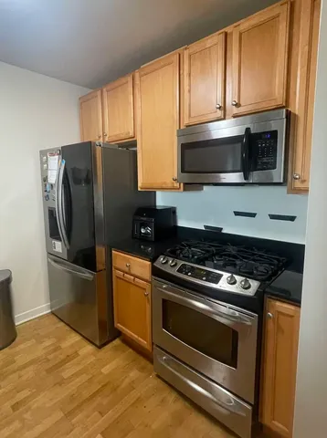 a kitchen with granite countertop wooden cabinets and stainless steel appliances