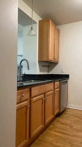 a kitchen with stainless steel appliances granite countertop a sink a stove and wooden cabinets