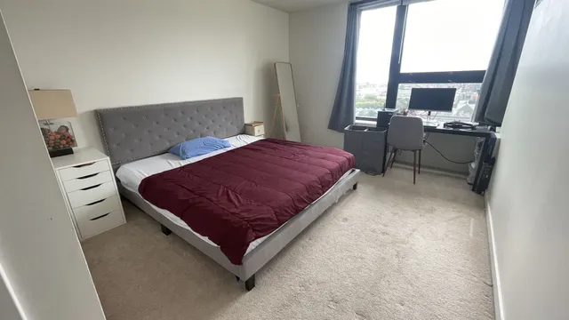 a living room with a bed furniture and a flat tv screen