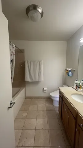 a bathroom with a granite countertop sink a toilet and a tub