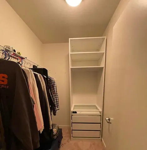 a view of walk in closet with clothes and shoes