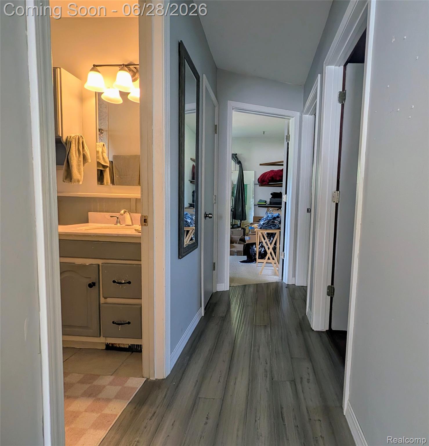 4456 East Coldwater Road Flint, MI 48506 - Photo 12 of 35 Hallway with wood-finish flooring, light grey painted walls, white trim, and doors
