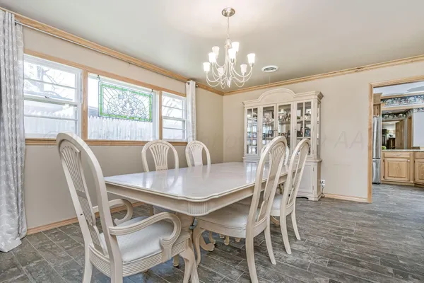 a dining room with furniture a chandelier and wooden floor