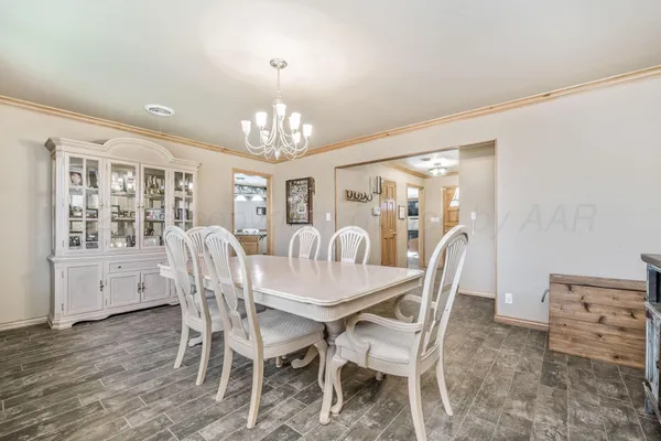 a view of a dining room with furniture a chandelier and wooden floor