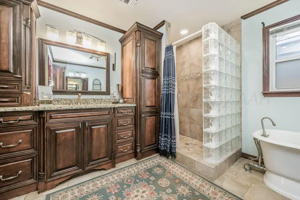 a bathroom with a granite countertop sink mirror and shower