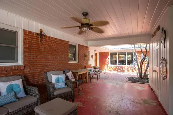 a living room with furniture ceiling fan and a large window