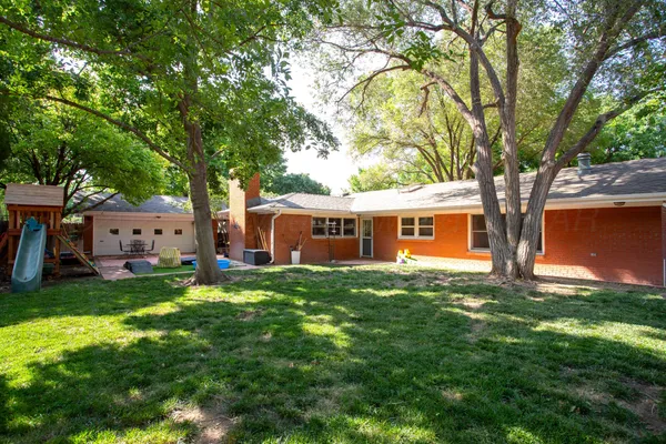 a view of a yard in front of a house with large trees
