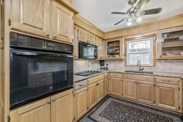a kitchen with stainless steel appliances granite countertop a sink and cabinets