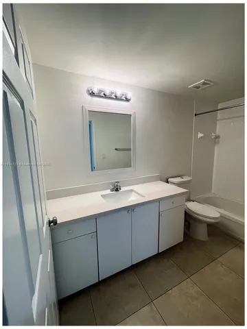 a bathroom with a double vanity sink mirror and toilet