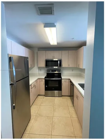 a kitchen with a refrigerator sink and cabinets