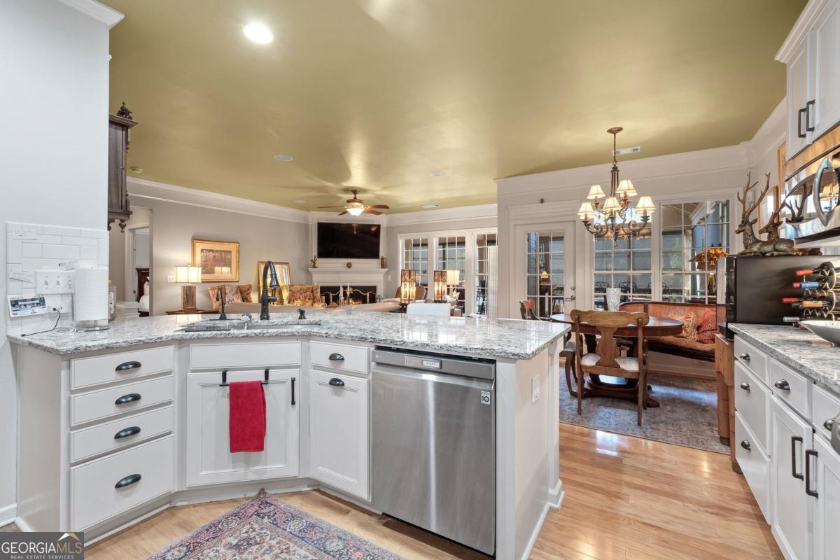 1151 Spring Station Road Greensboro, GA 30642 - Photo 20 of 60 a kitchen with kitchen island granite countertop a sink cabinets and stainless steel appliances