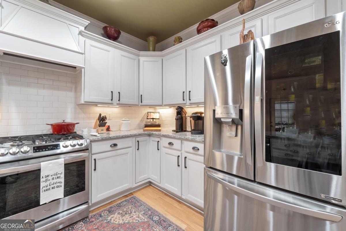 1151 Spring Station Road Greensboro, GA 30642 - Photo 22 of 60 a kitchen with stainless steel appliances granite countertop a stove a sink and a refrigerator