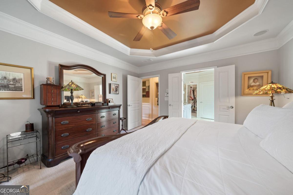 1151 Spring Station Road Greensboro, GA 30642 - Photo 24 of 60 a bedroom with a bed and a large mirror with a chandelier