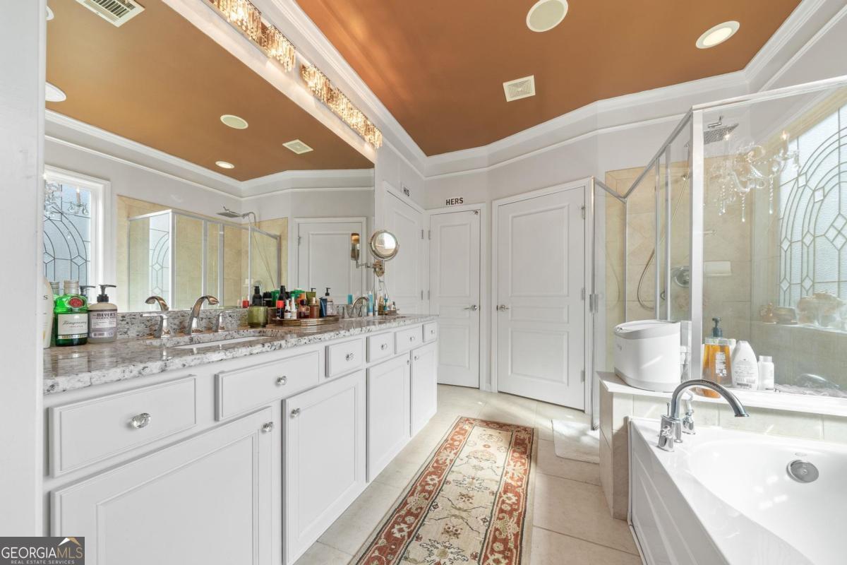 1151 Spring Station Road Greensboro, GA 30642 - Photo 27 of 60 a spacious bathroom with a double vanity sink a mirror and a bathtub
